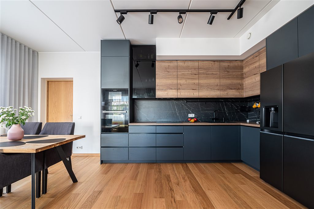 Wood-decor laminated fronts next to graphite fronts and black appliances